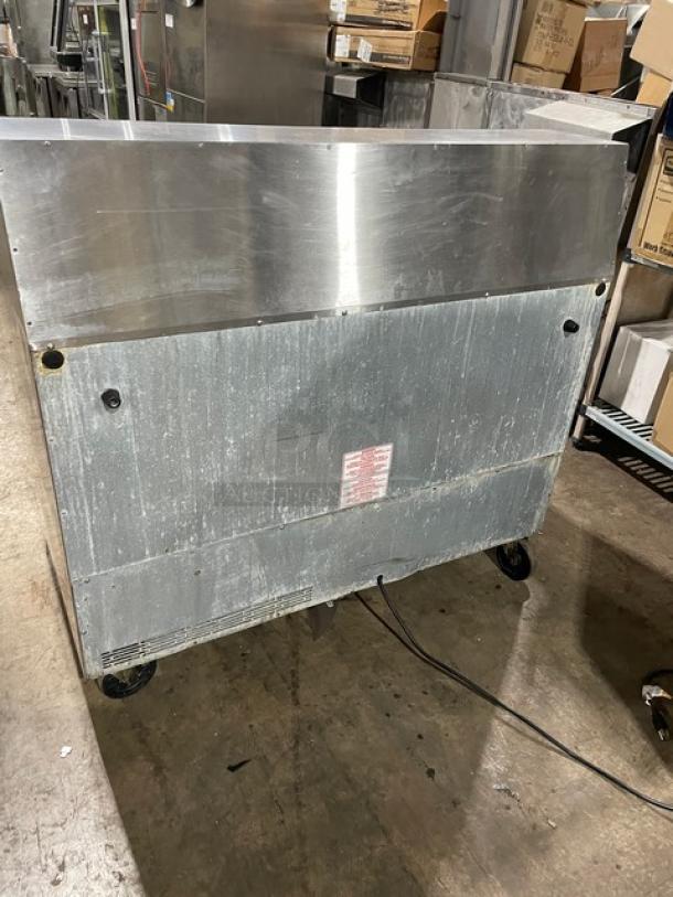 Commercial stainless steel refrigerated salad/sandwich prep table on casters with cutting board, good condition.