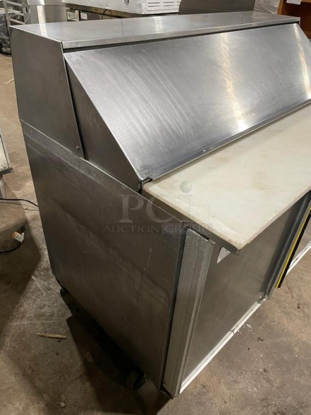 Commercial stainless steel refrigerated bain marie salad/sandwich prep table with cutting board, on casters.
