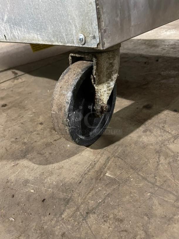 Commercial stainless steel refrigerated prep table on caster, featuring Bain Marie style, includes cutting board.