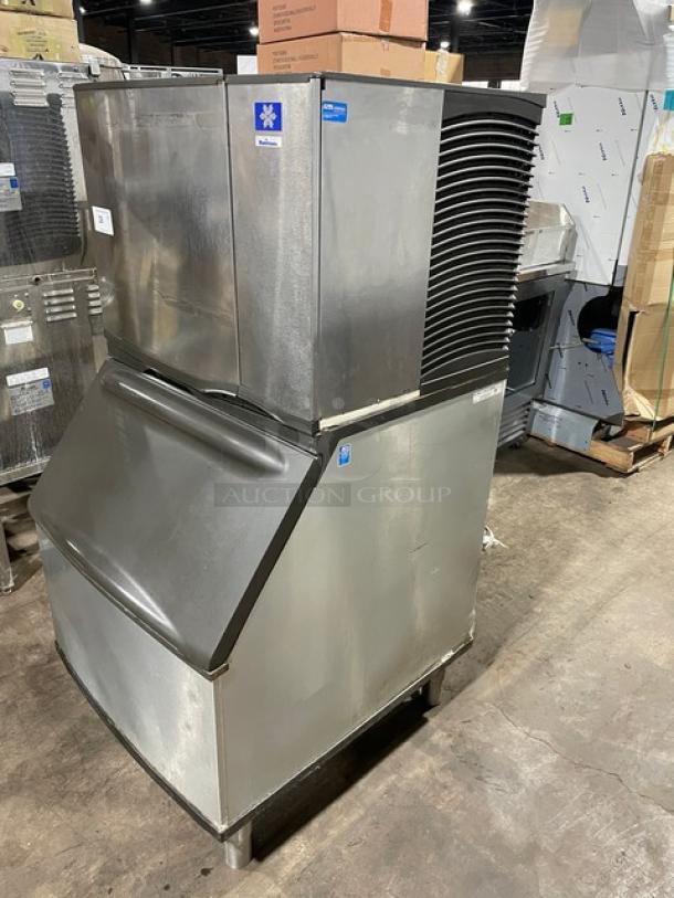 Manitowoc stainless steel electric ice maker/bin combo with lift open access, on legs, in used condition.