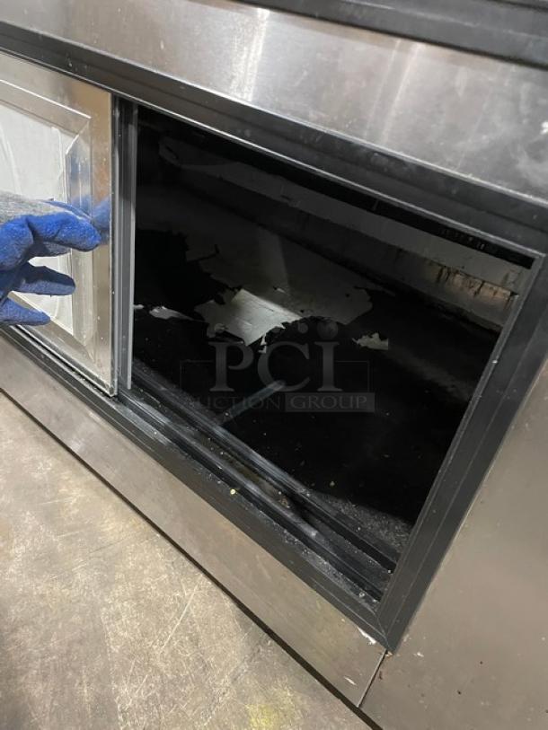 Leader HDL72SC stainless steel refrigerated merchandiser. Slanted glass, adjustable shelving, rear sliding doors. Used condition.