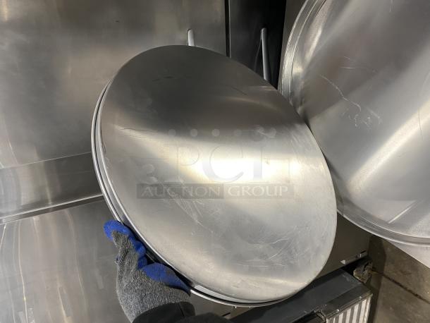 Commercial aluminum round pizza pan, lightly used, stack of four included, durable surface, suitable for high-volume use.