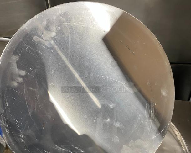 Commercial aluminum round pizza pan with a smooth surface and light wear, suitable for professional kitchens.