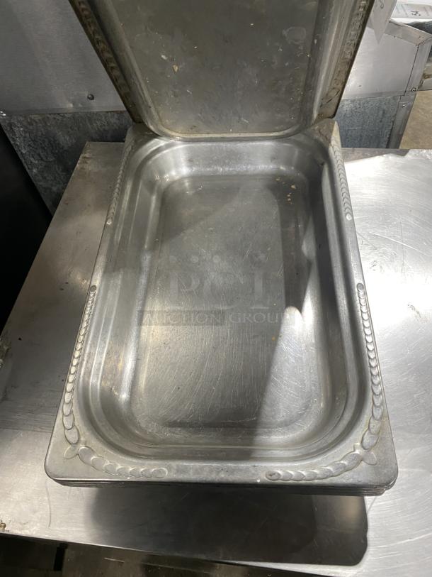 Commercial stainless steel stackable food serving tray, rectangular, decorative edge, lightly used, ideal for catering.