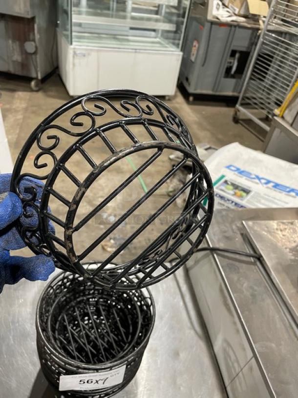 Commercial black round wired basket with decorative scrollwork. Measures approximately 9 inches. Condition: appears used.
