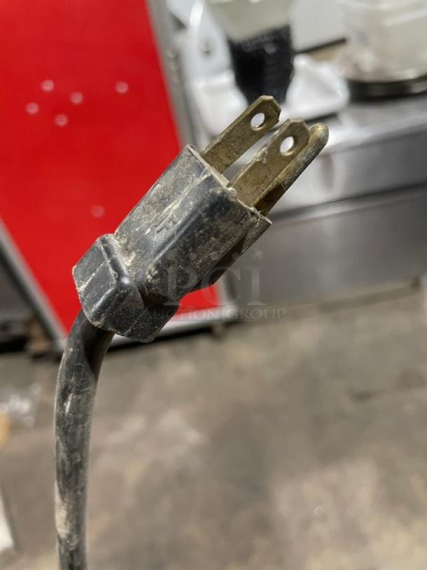 Close-up of a worn power plug for a Berg EDRF23BERG commercial freezer, indicating the need for potential replacement.