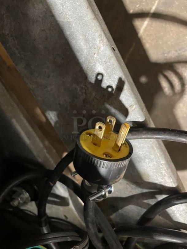 A power plug for a Beverage Air MT12 cooler, showing a three-prong design, attached to a black cable.