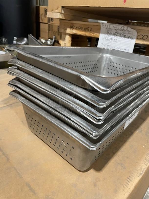 Commercial stainless steel full-size perforated steam table buffet pan, stacked, used condition, durable kitchenware.