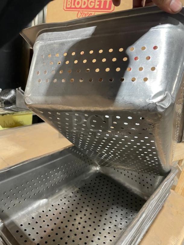 Commercial stainless steel perforated steam table buffet pan in new condition. Stacked pans visible, sturdy design.