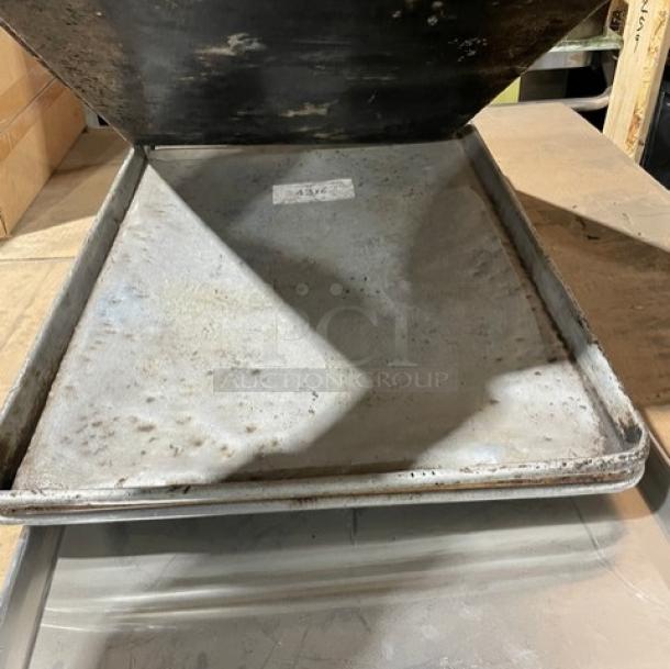 Commercial aluminum full-size sheet pan, showing signs of use. Ideal for baking, durable, with visible wear.