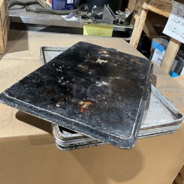 Commercial aluminum full-size sheet pans, used condition with visible wear and discoloration. Auction offers 7 units per bid.