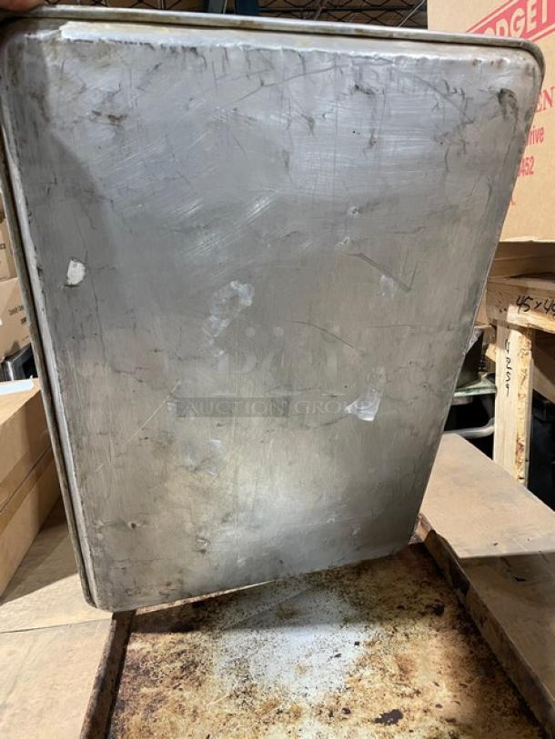 Commercial aluminum full-size sheet pan, shows wear and scratches, durable and suitable for high-volume baking.