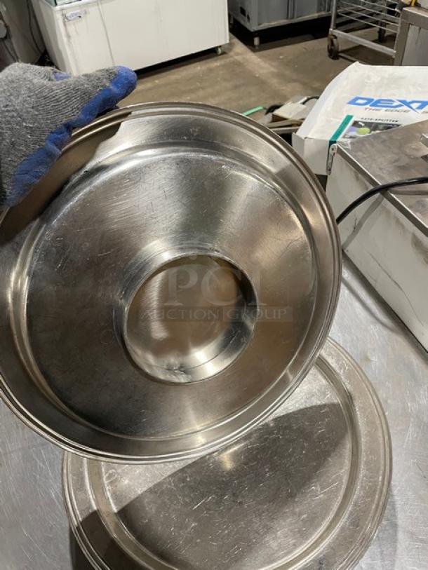 Commercial stainless steel plates, slightly scratched, round design. Durable construction; ideal for heavy-duty use.