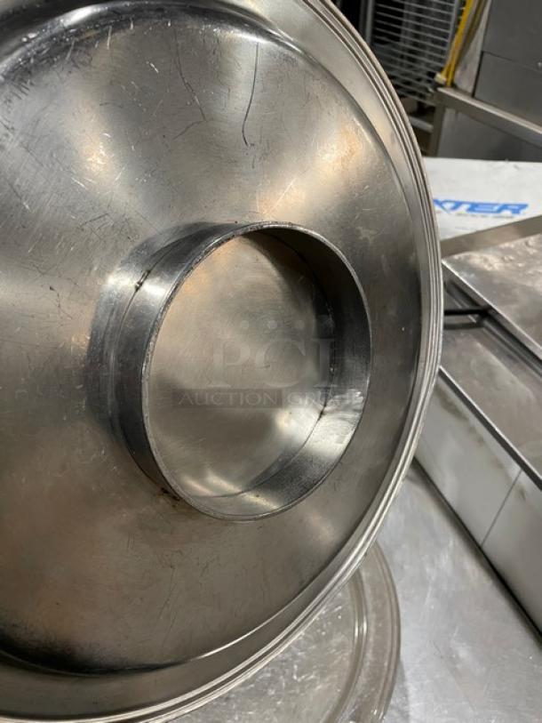 Commercial stainless steel plate with central mounting feature, polished finish, some surface scratches, ideal for heavy-duty use.