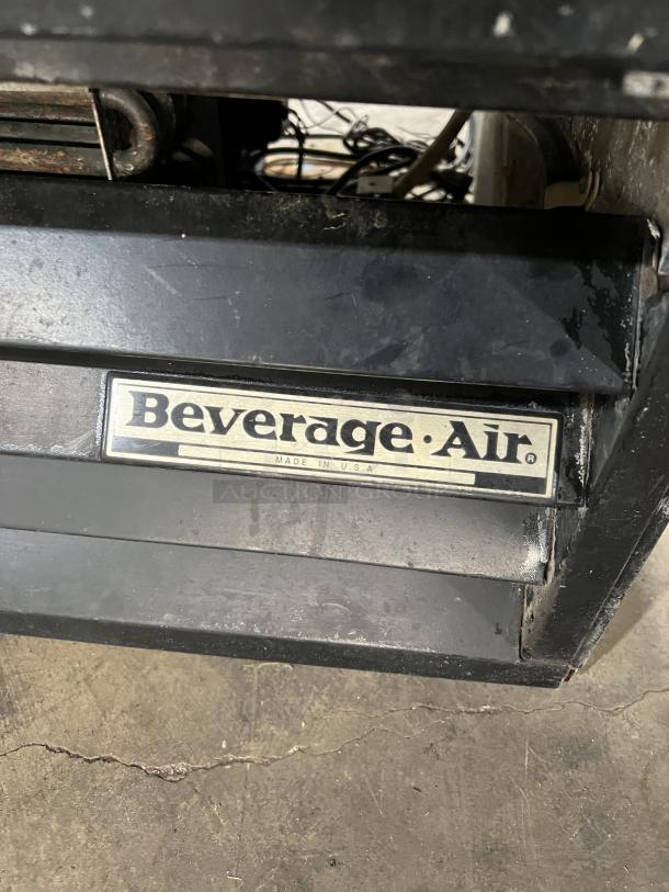 Close-up of Beverage Air Commercial Refrigerator, model MT27; worn condition, black exterior, visible brand label.