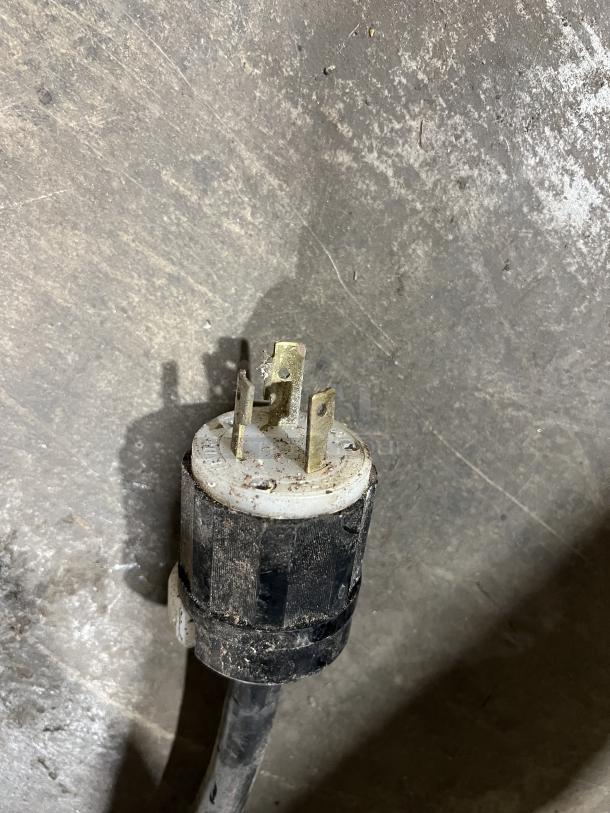 Close-up image of a power plug for a TurboChef Commercial Turbo Oven, showing metal prongs and a worn casing.