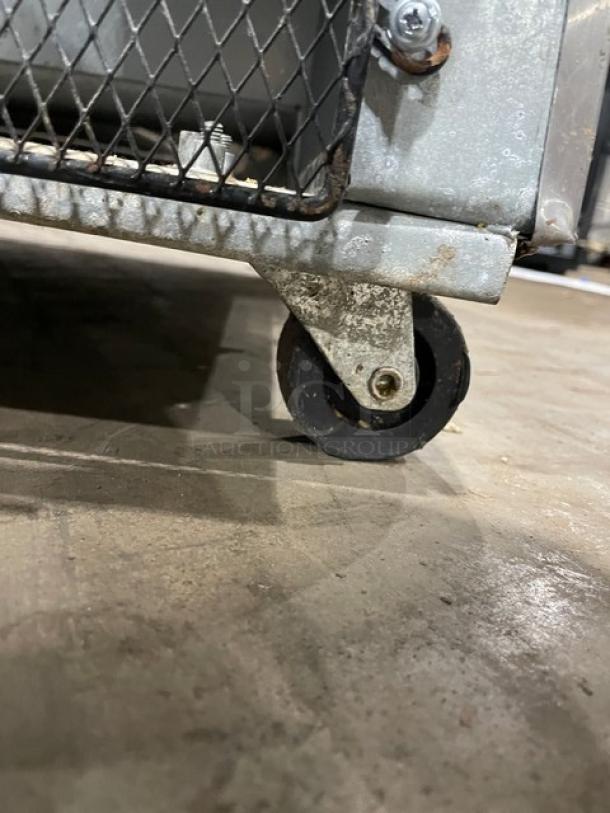 Stainless steel caster wheel beneath Sun Ice Model LUNST72-30 refrigerated prep table, showing metal frame and mesh detailing.
