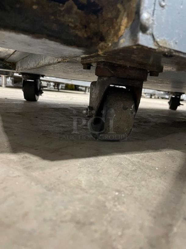 True TSUU4808 stainless steel refrigerated pizza prep table wheel, showing rust and wear. Model: TSUU-48-08 SN: 4940880.