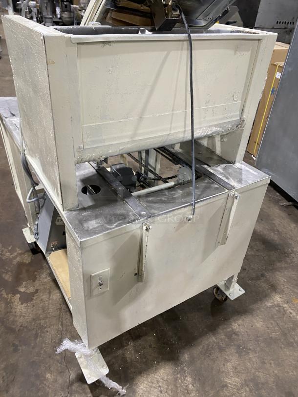 Commercial stainless steel dough sheeter machine, industrial-grade, used condition, signs of wear, robust construction.