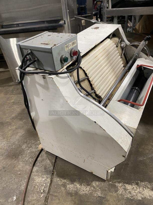 Merand Tenor 2 electric countertop dough moulder in used condition. Features white casing, visible control box, and conveyor rollers.