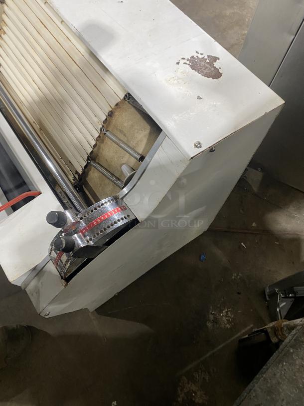 Merand Tenor 2 commercial electric dough moulder in white, vertical design. Visible wear on surface, functional controls.