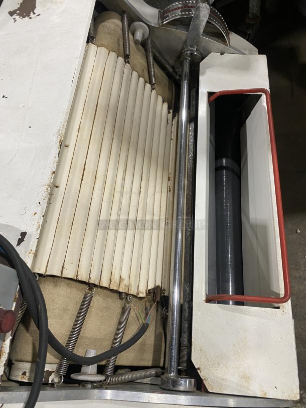 Merand Tenor 2 electric countertop dough moulder, used condition, vertical design, visible springs and rollers.