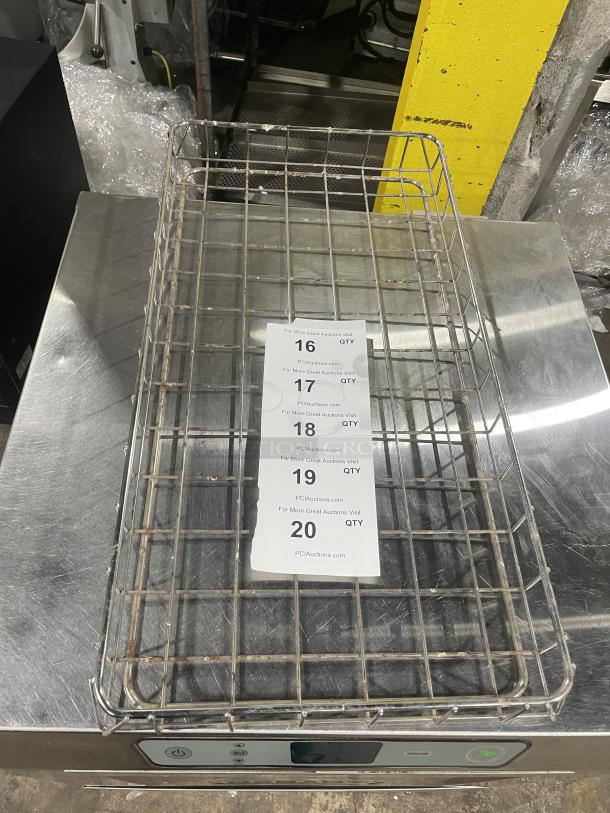 Commercial stainless steel wired bagel basket, rectangular, used condition, with visible grid wire design and auction tag.