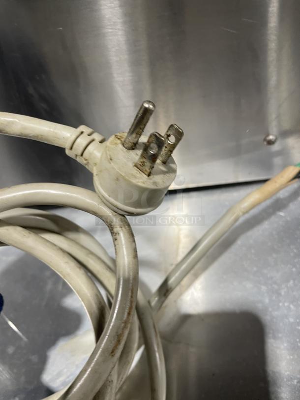 Electric plug and cord of Croydon OR4E-100001W5 stainless steel countertop griddle, showing signs of use.