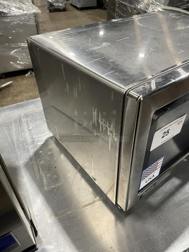 Amana RCS10DSE commercial stainless steel microwave, 2023 model. Some surface scratches visible, 120V. USA label on door.