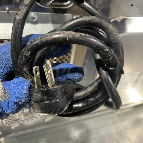 Coiled power cord of Amana RCS10DSE commercial stainless steel microwave, showing standard plug; item in used condition.