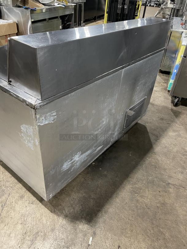 Stainless steel 2-door refrigerated bain marie prep table, includes cutting board, poly-coated rack, on casters, shows wear.