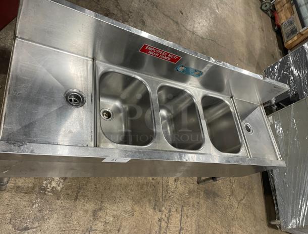 Eagle Group Spec-Bar 2000 Series stainless steel underbar sink, model B53LR19. Three compartments, left and right drain boards, backsplash, on legs. "Employees Must Wash Hands" sign visible.