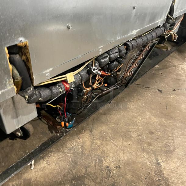 Delfield model UCD4464N12DD5 refrigerated prep table, 4 drawers, visible internal wiring and components, stainless steel.