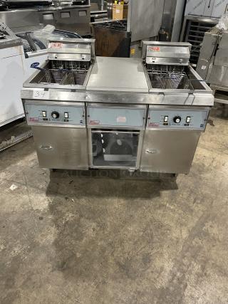 Pitco Frialator 2-Bay Deep Fat Fryer System with basket hanger, center pan cabinet, backsplash, casters; stainless steel.