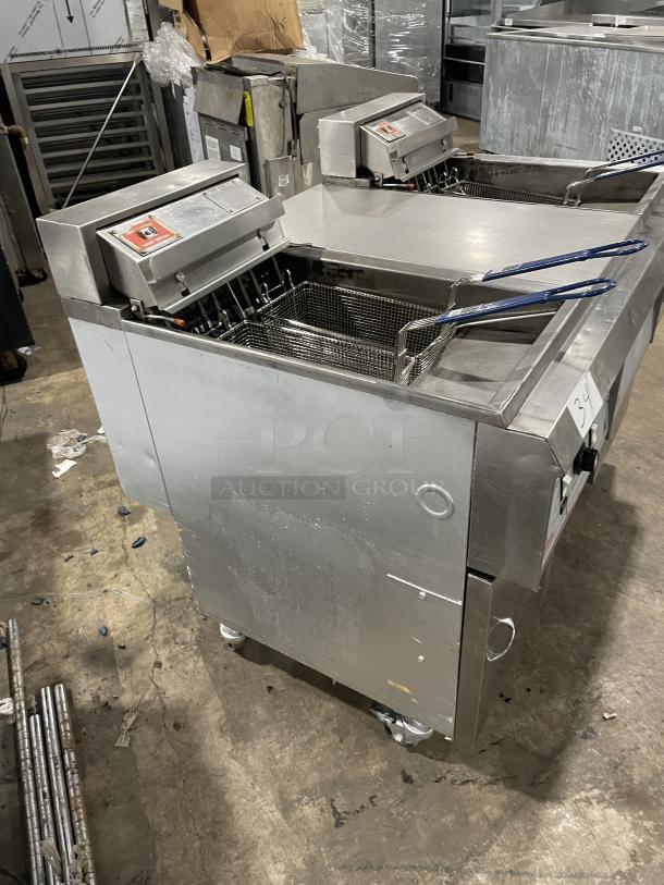 Pitco Frialator Series commercial stainless steel 2-bay deep fat fryer system with center cabinet, backsplash, and basket hanger.