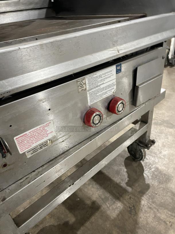 Lang 224THNATMG stainless steel natural gas countertop clamshell griddle with equipment cart, on casters, visible wear.
