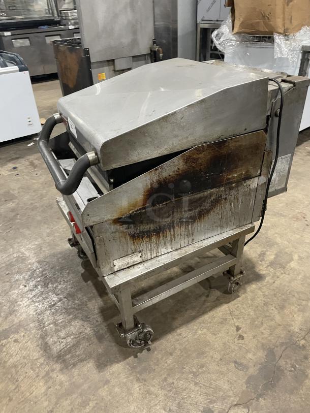 Lang commercial stainless steel infrared clamshell griddle, Model 224TH-NATMG, on equipment stand with casters, shows wear.