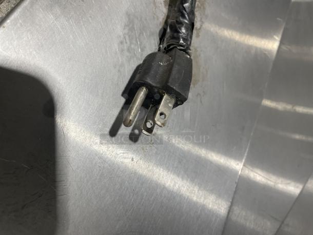 Lang Model 224THNATMG stainless steel clamshell griddle plug. Natural gas powered, on a mobile equipment cart.