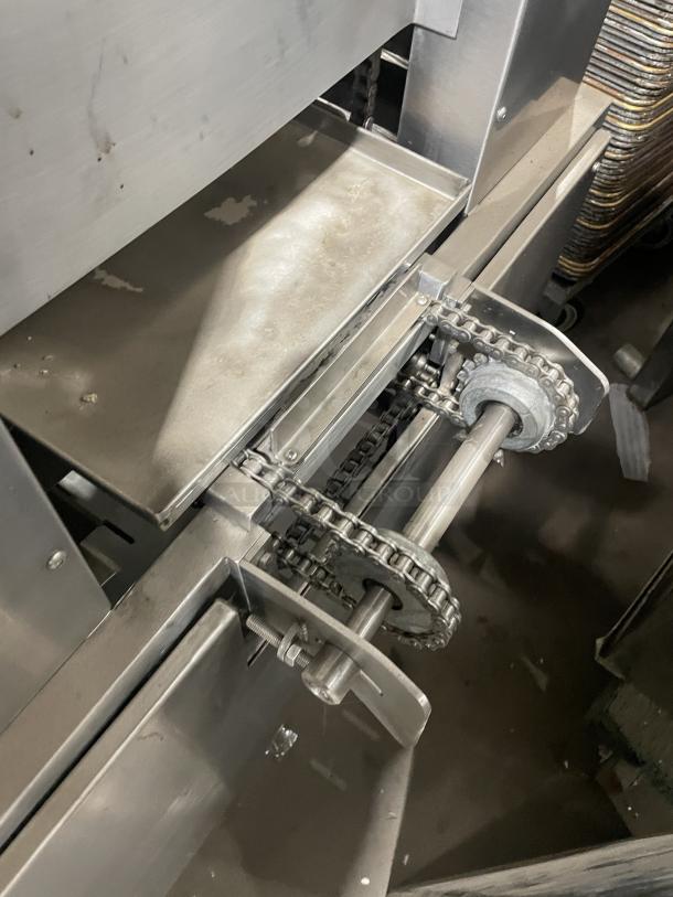 Aksar floor-style heavy-duty commercial tray wrapping machine in used condition, features visible chain mechanism.