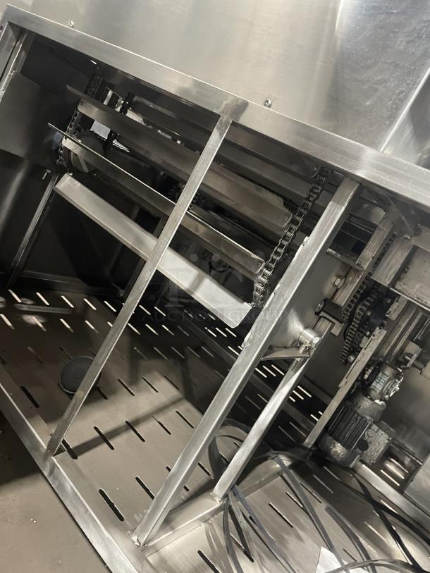 Aksar floor style heavy duty commercial tray wrapping machine, metallic finish, visible chains and motor, industrial use.