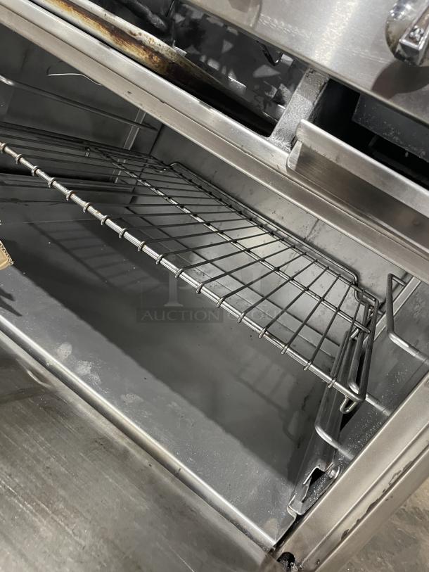 Jade Range gas-powered 4 burner and charbroiler combo with full-sized oven, on commercial casters. Clean interior.