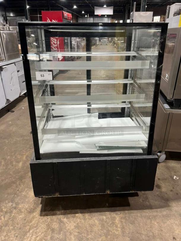 Marchia MBST36 refrigerated bakery display case, 3-tier, 115V, in good condition, clear glass, black frame, internal shelving visible.