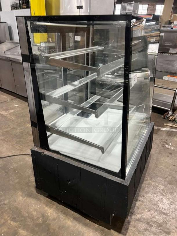 Marchia MBST36 refrigerated 3-tier bakery display case in good condition, 115V 1 Phase, black frame, glass shelves.