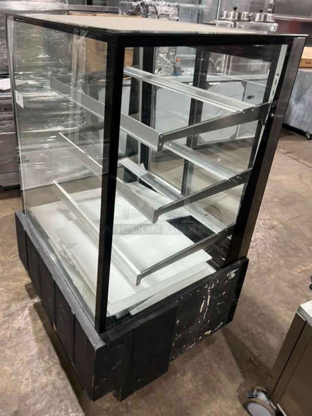 Marchia MBST36 3-tier refrigerated bakery display case, clear glass, black trim, 115V, used, features adjustable shelves.