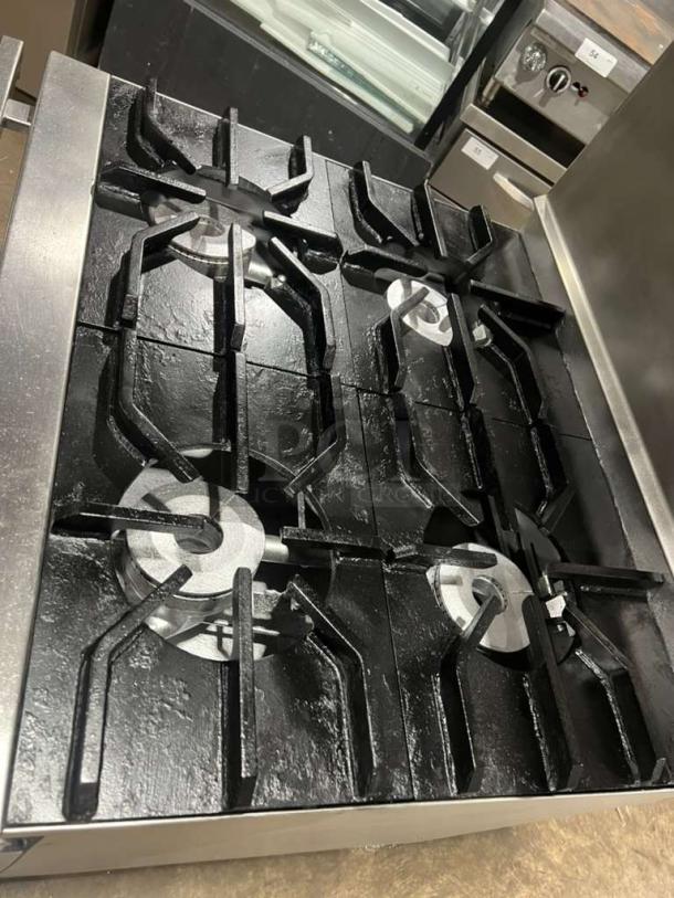 Jade Range heavy-duty 4-burner gas range with full-size oven, raised double shelf backsplash, and casters.