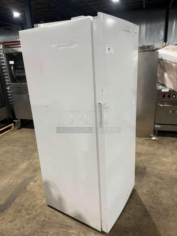Frigidaire upright freezer, model FFFU16F2VW, white, serial 8A24905993, 115V, 1 phase. Good condition, free-standing design.