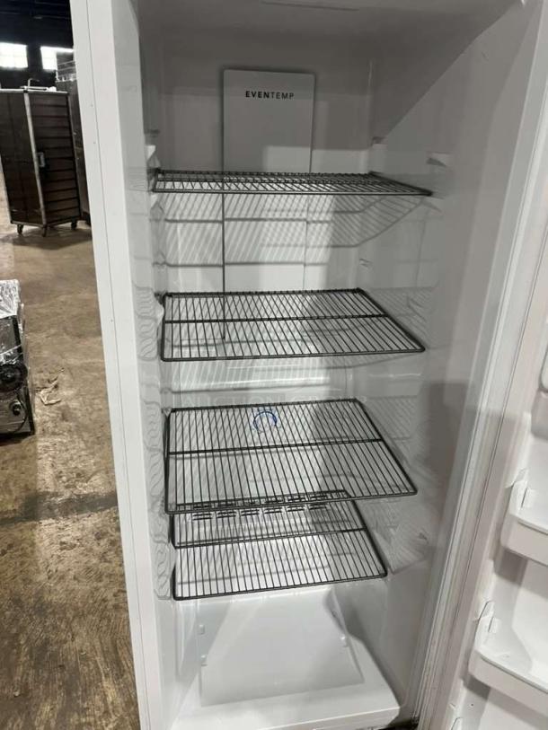 Frigidaire upright freezer, model FFFU16F2VW, 115V, 1 phase, features sturdy wire shelves, clean interior.
