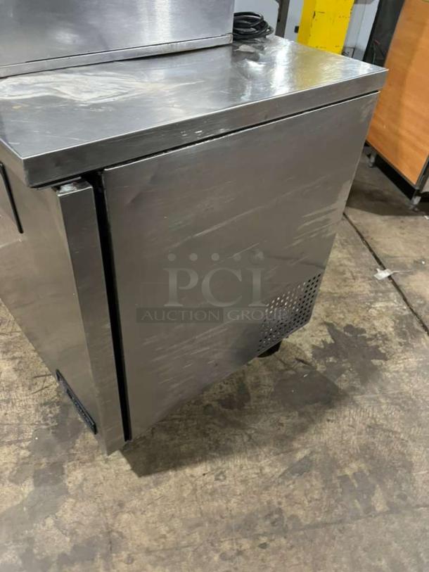 True TUC60 refrigerated 2-door lowboy worktop cooler with storage, on casters. Stainless steel finish, slight surface wear.
