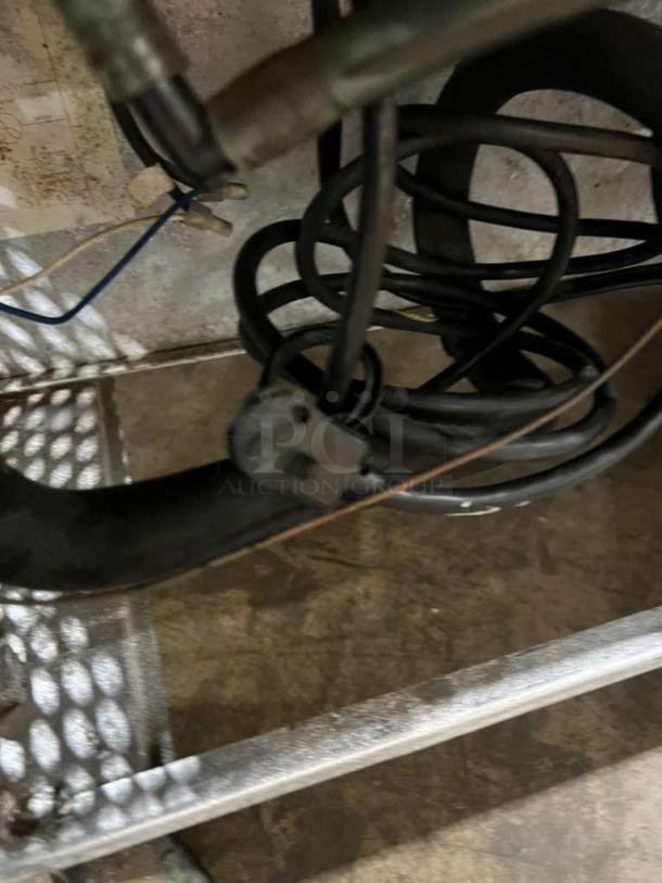 Close-up of True model TUC60 lowboy cooler's components, showing electrical wiring and metal frame.