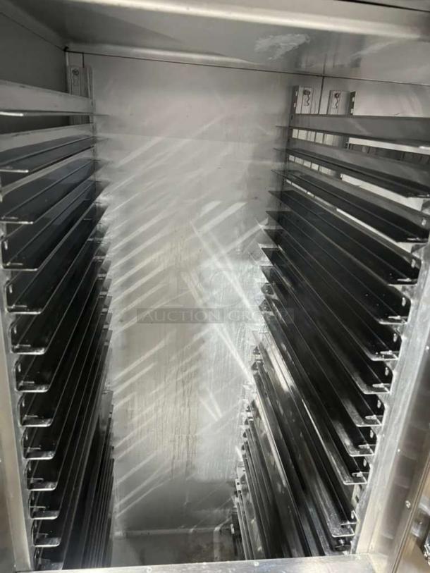 Traulsen AHT2-32 refrigerator interior with built-in pan racks, clean condition, stainless steel, serial 227791, on legs.